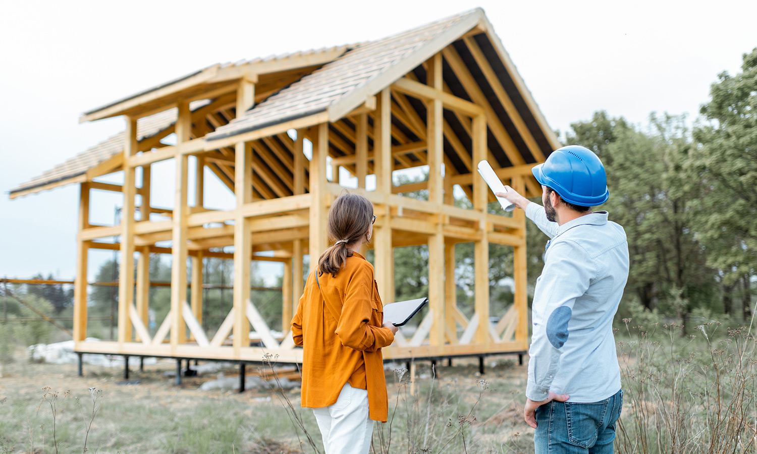 Male builder showing female client house frame