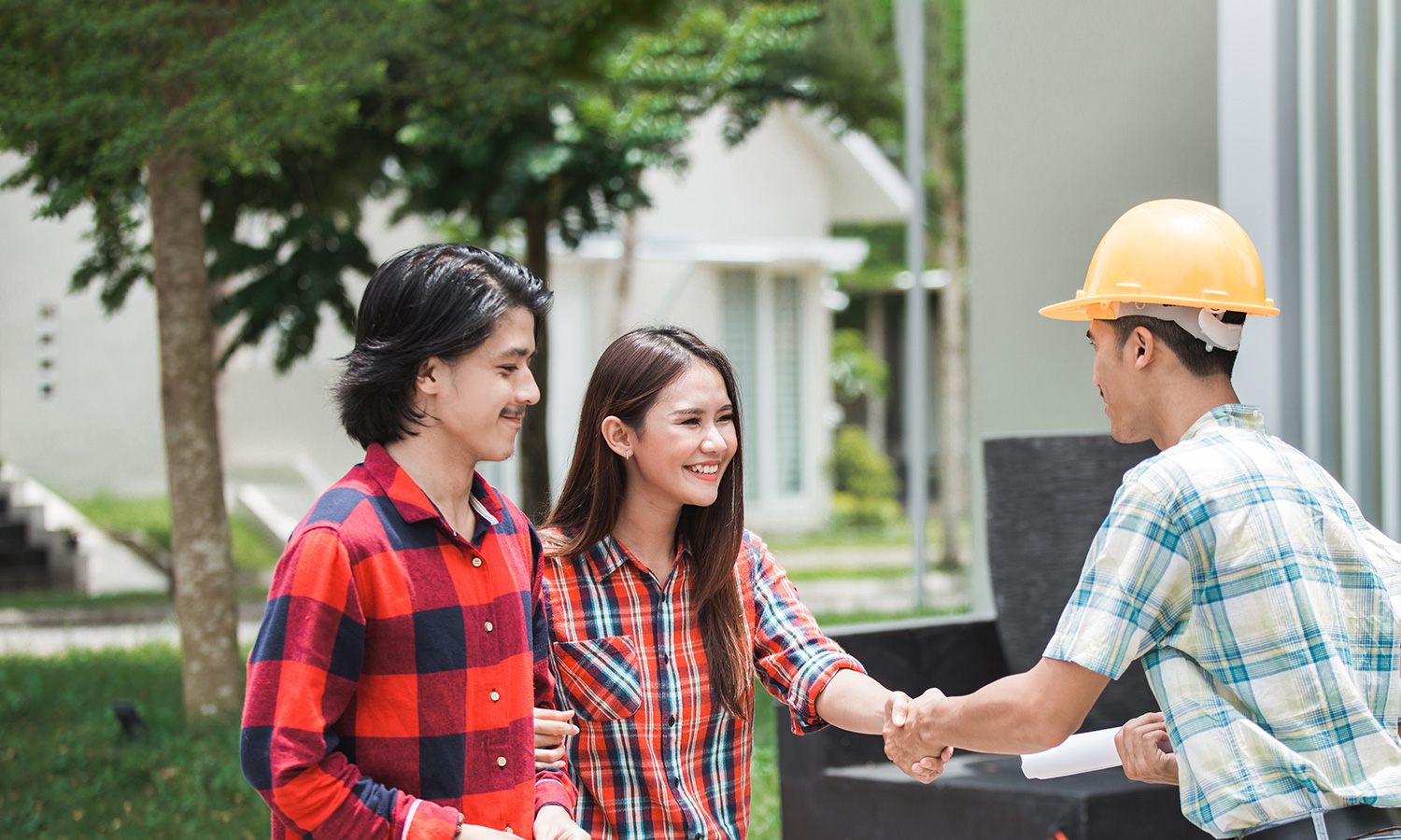 Happy couple shaking hand with builder